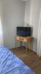 a television on a wooden table in a room at Ferienwohnung Christel in Erlenbach am Main