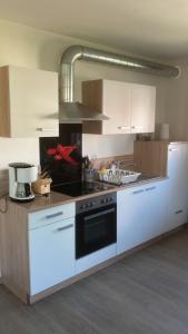 a kitchen with white cabinets and a stove top oven at Ferienwohnung Christel in Erlenbach am Main