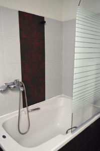 a bathroom with a tub with a glass shower door at Ευρύχωρο διαμέρισμα στο κέντρο της πόλης in Kastoria