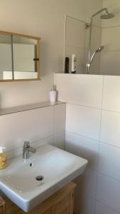a bathroom with a white sink and a mirror at Ferienwohnung Christel in Erlenbach am Main