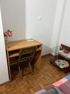 een bureau met een stoel en een tafel met een vaas met bloemen bij Habitacion doble en Figueres in Figueres