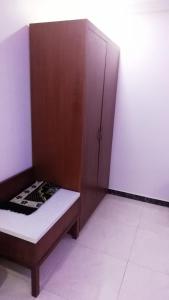 a small bedroom with a bed and a closet at Ashbilia Suites in Al Khobar