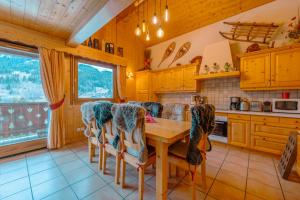 a kitchen with a wooden table and chairs at chalet Amitie familial de luxe avec JACUZZI, HEBERGEMENT MULTIPASS ETE, WIFI fibre, 150 m des pistes de ski et randonnées in Les Gets +42 photos