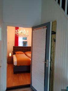 een slaapkamer met een bed en een deur naar een kamer bij Huisjeaandedinkel in Overdinkel