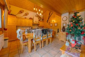 una cocina con una mesa y un árbol de Navidad en superbe chalet Amitie jacuzzi proche lac et du centre avec reduction multipass ete, en Les Gets