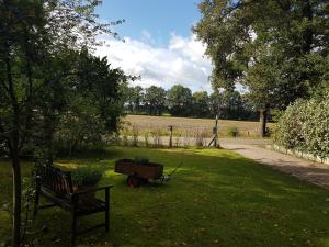 een park met een bank en een kar in het gras bij Huisjeaandedinkel in Overdinkel