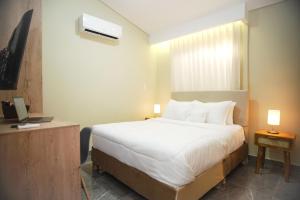 a hotel room with a bed and a television at Bahía Boutique House in Cartagena de Indias