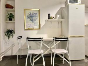 a kitchen with two chairs and a table and a refrigerator at « Nice et confortable » 2 pièces cozy in Nice