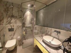 een badkamer met een wastafel, een douche en een toilet bij Maxxvalue Hotel MIDC - Andheri in Mumbai