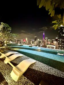 uma piscina com vista para a cidade à noite em AXON RESIDENCE AT BUKIT BiNTANG KUALA LAMPUR em Kuala Lumpur
