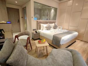 una camera da letto con un letto, due sedie e un tavolo di Maxxvalue Hotel MIDC - Andheri a Mumbai