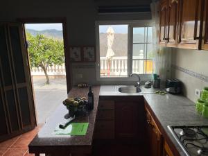 Una cocina con encimera con fregadero y ventana. en Casa Verde, en Vallehermoso