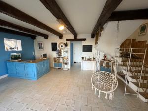 a kitchen with blue cabinets and a swinging chair at Chambres d'hôtes la Bégaudière in Dol-de-Bretagne