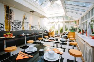 - un restaurant avec des tables et des chaises dans une salle dans l'établissement Henley House Hotel, à Londres