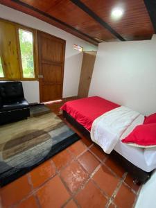 sypialnia z łóżkiem i krzesłem w obiekcie CABAÑA LOS NOGALES w mieście San Agustín