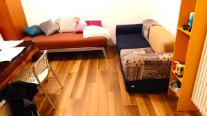 a small room with a couch and a wooden floor at Cozy!! Verona in Verona