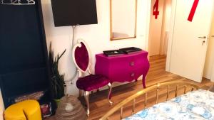 ein Zimmer mit einem rosa Stuhl und einem Spiegel in der Unterkunft Cozy!! Verona in Verona