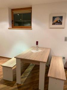 een houten tafel met een wijnglas erop bij Ferienwohnung Sophia in Inzing
