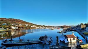 una barca è ormeggiata in un molo in un fiume di Anchor Hotel and Seabed Restaurant a Tarbert