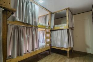 um quarto com 2 beliches e cortinas em Argdivan Hostel em La Fortuna