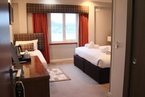 una camera d'albergo con un letto e una finestra di Anchor Hotel and Seabed Restaurant a Tarbert