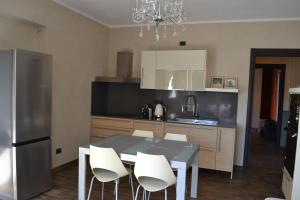 a kitchen with a dining table and white chairs at ElleCi Casa Vacanze in Mondovì