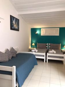 1 dormitorio con 2 camas y pared verde en Pousada dos Pássaros Geribá, en Búzios