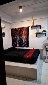 a bed in a room with a painting on the wall at BTL Sunny in Bang O