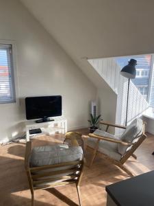 a living room with two chairs and a flat screen tv at NEW Appartment Zandvoort! in Zandvoort