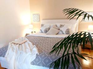 um quarto com uma cama com uma planta no primeiro plano em Léna Apartman - Eger em Eger