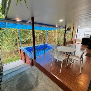 a room with a table and chairs and a swimming pool at The Orchard Private Villa with Pool and Wifi in Cuenca Batangas in Cuenca