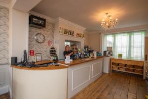 a woman is standing behind a counter in a room at Alexandra Hotel in Weymouth