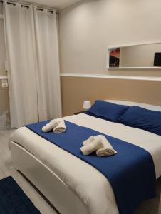 sypialnia z łóżkiem z ręcznikami w obiekcie House Lurokè w Katanii