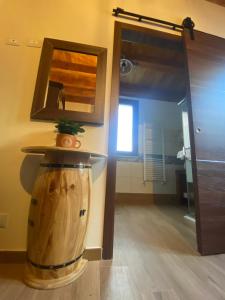a bathroom with a mirror and a wooden barrel at SUTTA L'ARCHI in Alia