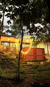a house with a tree and lights in the yard at The Orchard Private Villa with Pool and Wifi in Cuenca Batangas in Cuenca