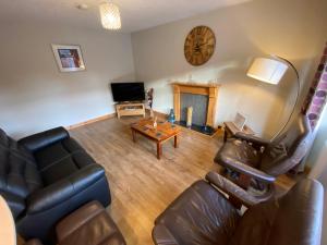 a living room with a couch and a fireplace at Lyngarrie in Dufftown