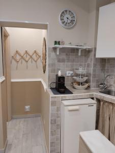 a kitchen with a sink and a clock on the wall at House Lurokè in Catania