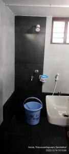 a bathroom with a bucket next to a sink at Annie's Villa in Kovalam +81 photos