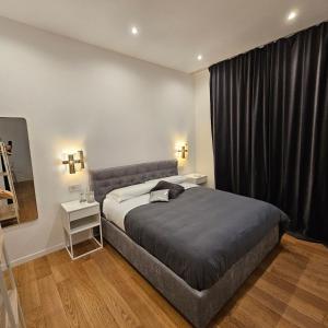 a bedroom with a bed and a black curtain at Cozy Apartment between Sempione, City Life and MiCo ! in Milan