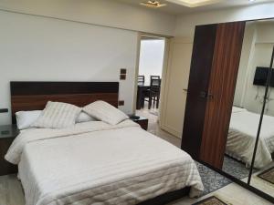 a bedroom with a large white bed and a mirror at City Square in Alexandria