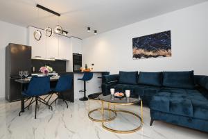 a living room with a blue couch and a table at Luxury Apartment Gloria Old Town Zadar with Sea View in Zadar