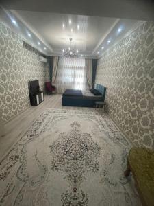 ein Schlafzimmer mit einem Bett und einem Teppich in einem Zimmer in der Unterkunft ЖК Green Plaza in Aqtau