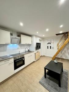 cocina grande con armarios blancos y mesa negra en Micro Apartment Leipzig, en Leipzig