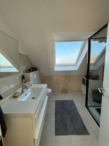 a white bathroom with a sink and a window at Maisonette Wohnung Frechen City in Frechen