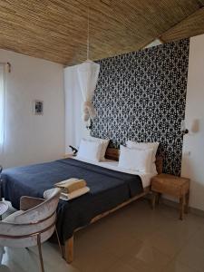 a bedroom with a bed with a black and white wall at La Fandenoise in Thiès