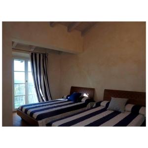 two beds sitting in a room with a window at Appartamento Matilde in Monti di Licciana Nardi +32 photos