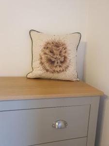 a pillow on top of a wooden dresser at Gardeners Cottage near the Norfolk Coast in Knapton