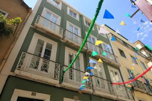 un edificio con banderas colgando de un balcón en Apartamento com varanda no centro de Lisboa, TTL269, en Lisboa