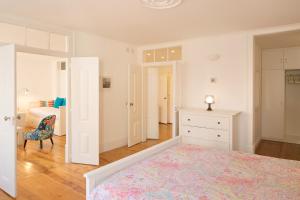 um quarto branco com uma cama e uma cómoda em Apartamento com varanda no centro de Lisboa, TTL269 em Lisboa