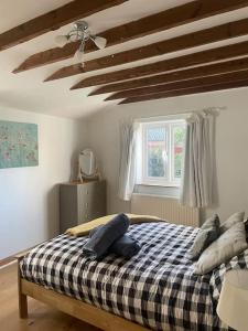 1 dormitorio con 1 cama con manta a cuadros en Gardeners Cottage near the Norfolk Coast en Knapton